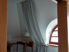 Záclonové tyče, závěsy a dekorace v hotelovém pokoji